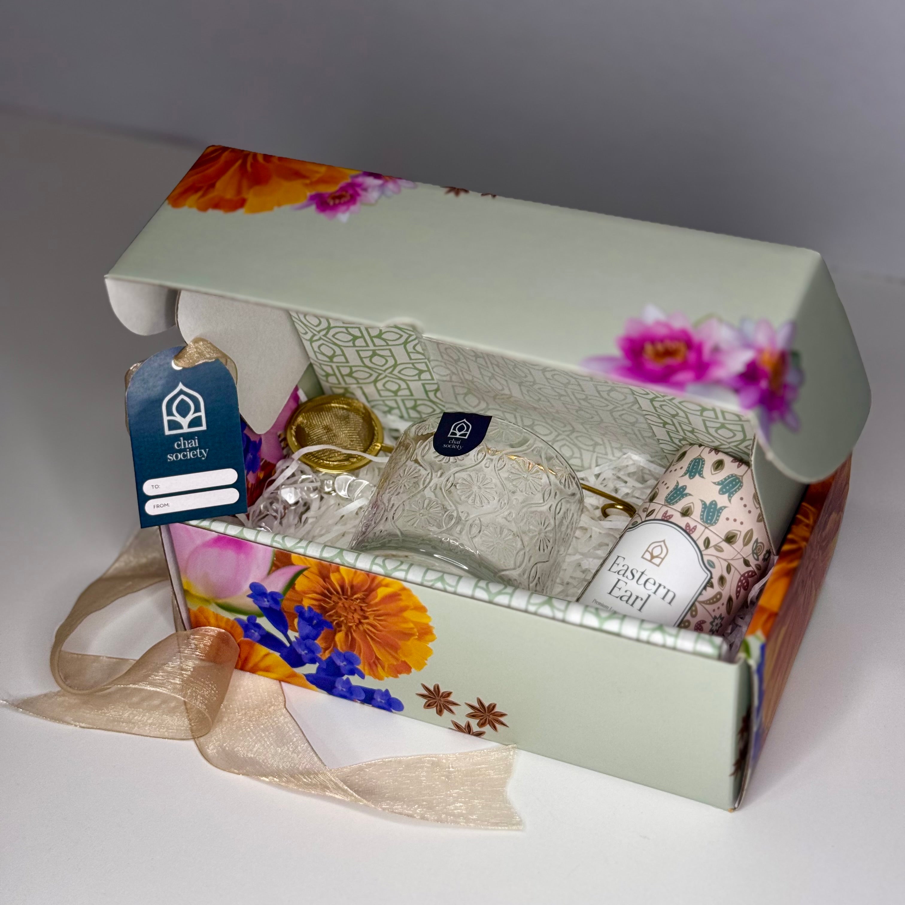  An open Chai's gift box containing Eastern Earl loose leaf tea and accessories, arranged as they appear when received