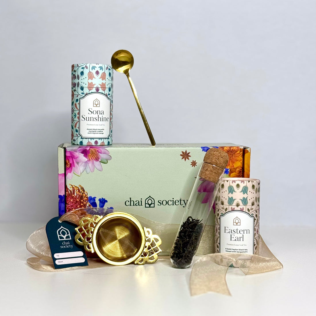 Chai's premium loose leaf tea gift box with glass infuser, gold strainer and gold spoon on white background
