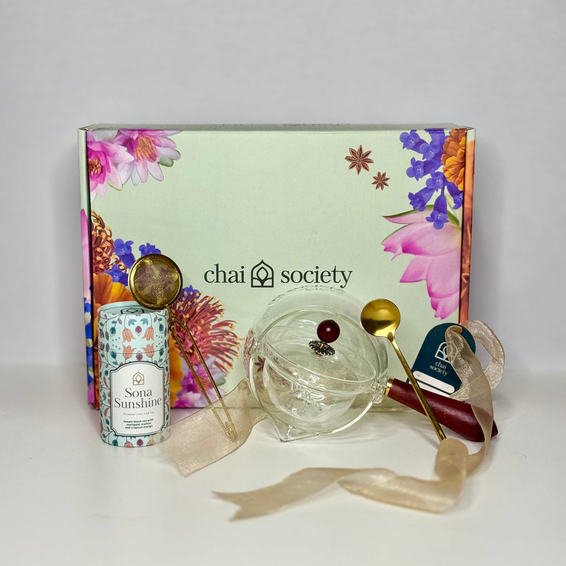 Chai's Storytellers pot styled with Sona Sunshine loose leaf tea blend and a gold spoon, presented in Chai's signature gift box — a thoughtful premium loose leaf tea gift for her