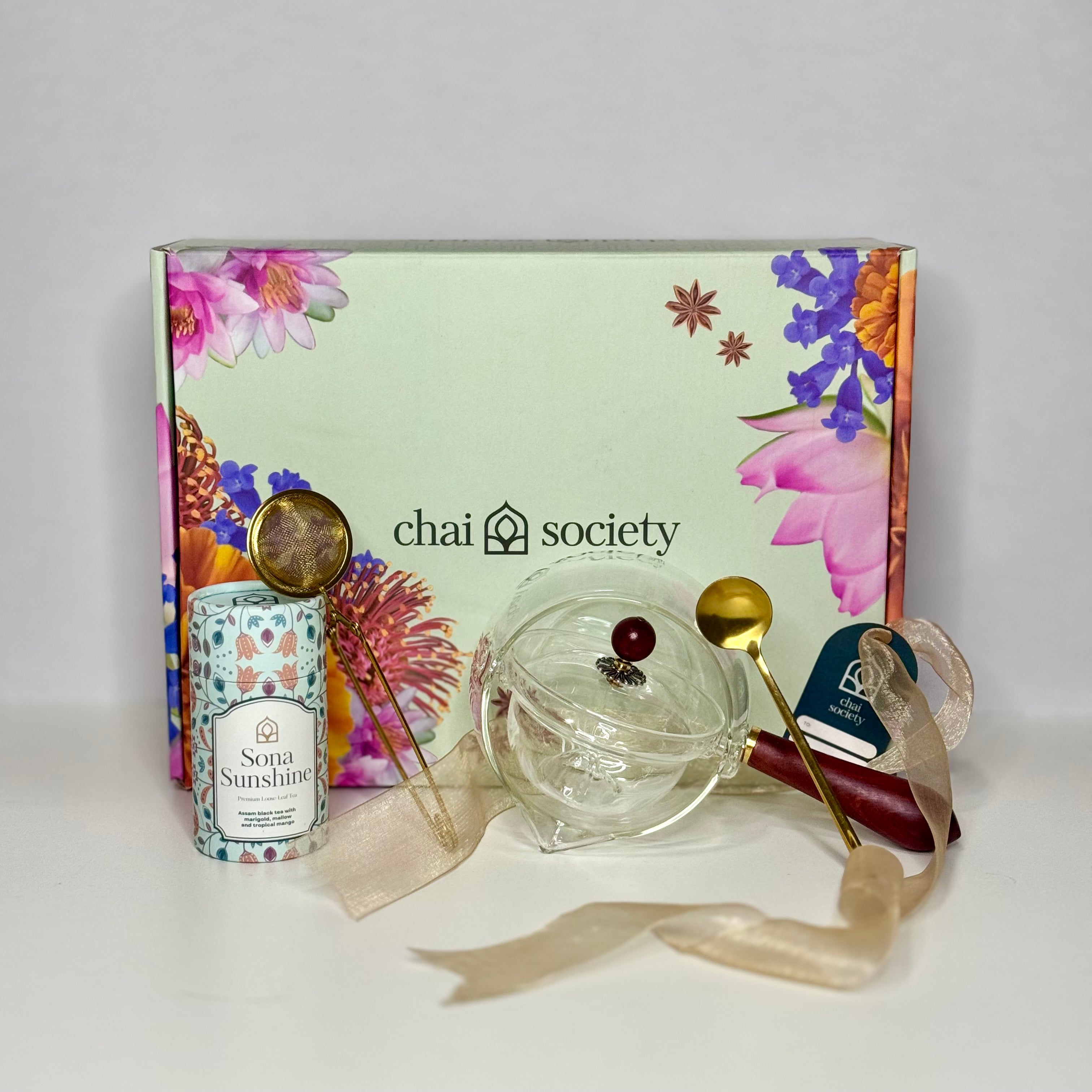 Chai's Storytellers pot styled with Sona Sunshine loose leaf tea blend and a gold spoon, presented in Chai's signature gift box — a thoughtful premium loose leaf tea gift for her