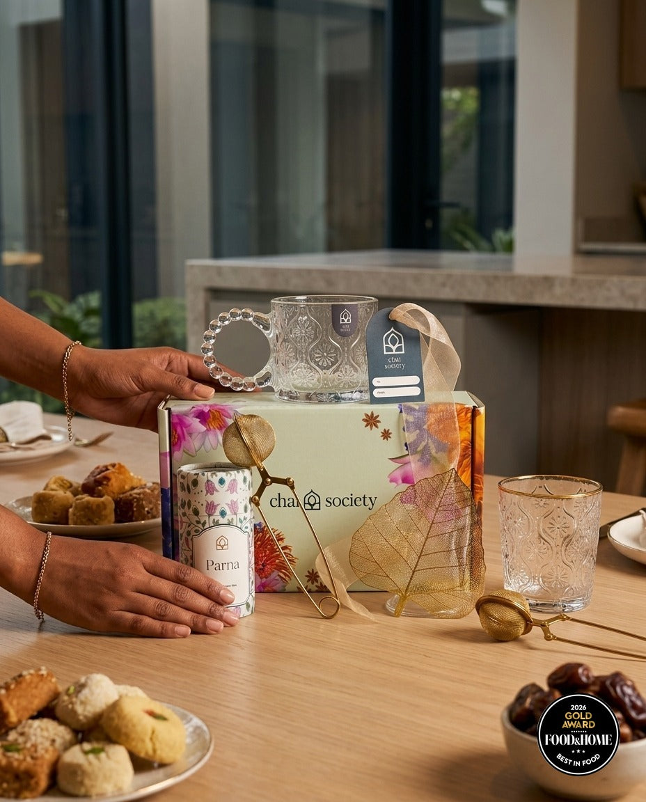 Chai Society gift box surrounded by Indian sweets and dates on a festive table